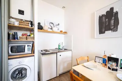 a kitchen with a washing machine and a microwave at Le refuge du Suquet, quartier authentique de Cannes, vue mer in Cannes