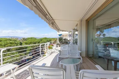 a row of white chairs and tables on a balcony at Sea View 95m Apartment with Large Terrace Cannes Croisette in Cannes