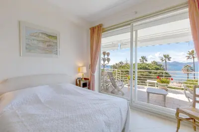 a bedroom with a bed and a large window at Sea View 95m Apartment with Large Terrace Cannes Croisette in Cannes