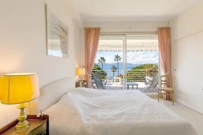 a bedroom with a bed and a view of the ocean at Sea View 95m Apartment with Large Terrace Cannes Croisette in Cannes