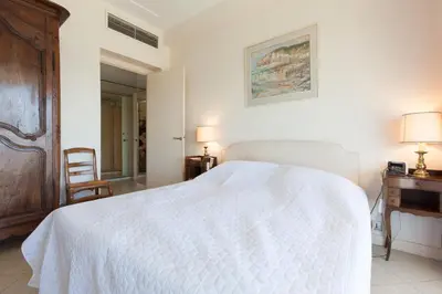 a bedroom with a white bed and a desk and a chair at Sea View 95m Apartment with Large Terrace Cannes Croisette in Cannes