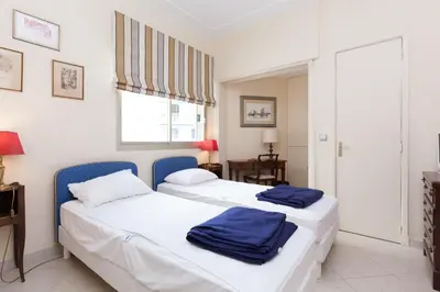 two beds in a room with white walls at Sea View 95m Apartment with Large Terrace Cannes Croisette in Cannes