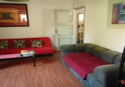 a living room with a couch and a red sofa at En ville un coin de campagne in Le Cannet