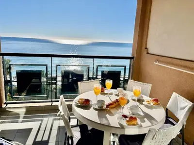 a living room with a blue couch and a balcony at Sun and Sea in Cannes