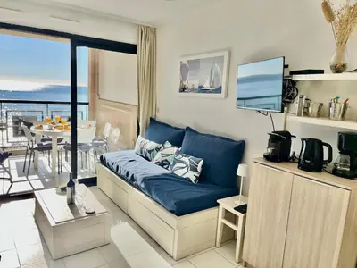 a room with a bed with a blue couch at Sun and Sea in Cannes