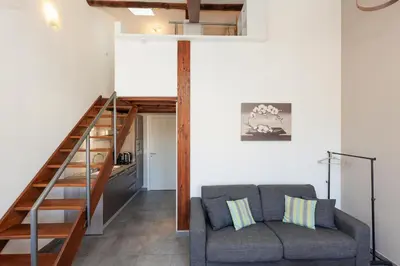 a living room with a couch and a staircase at Residence Aout 41 in Cannes