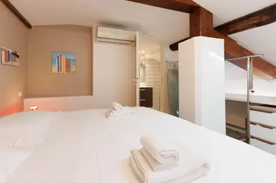 a bedroom with a white bed with towels on it at Residence Aout 41 in Cannes