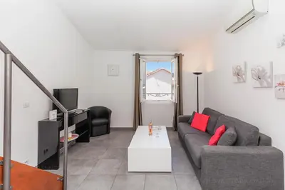 a living room with a couch and a table at Residence Aout 42 in Cannes