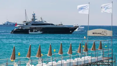a large boat in the water with a bunch of umbrellas at Residence Aout 42 in Cannes