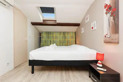 a bedroom with a large bed and a window at Residence Aout 42 in Cannes