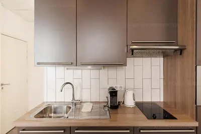 a kitchen with stainless steel cabinets and a sink at Residence Aout 32 in Cannes