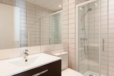 a white bathroom with a sink and a shower at Residence Aout 32 in Cannes