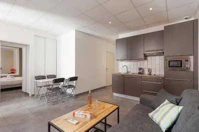 a kitchen and living room with a couch and a table at Residence Aout 32 in Cannes