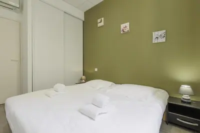a bedroom with a white bed with towels on it at Residence Aout 11 in Cannes