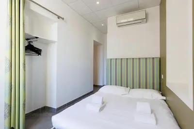 a room with two white beds in it at Residence Aout 21 in Cannes