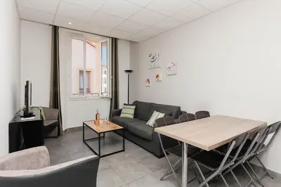 a living room with a couch and a table at Residence Aout 31 in Cannes