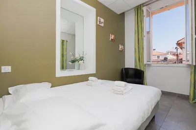 a bedroom with a large white bed and a window at Residence Aout 31 in Cannes