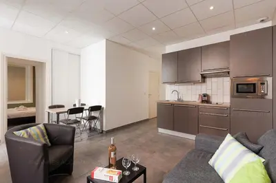 a living room with a couch and a kitchen at Residence Aout 22 in Cannes