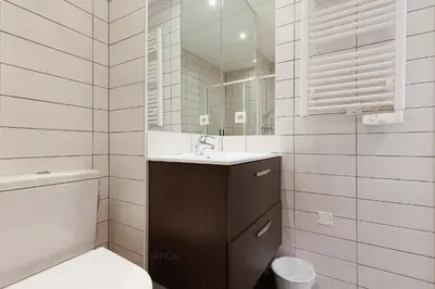 a white bathroom with a sink and a mirror at Residence Aout 22 in Cannes