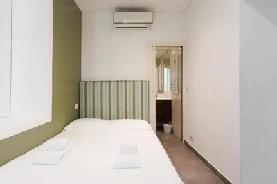 a small bedroom with a bed and a bathroom at Residence Aout 22 in Cannes