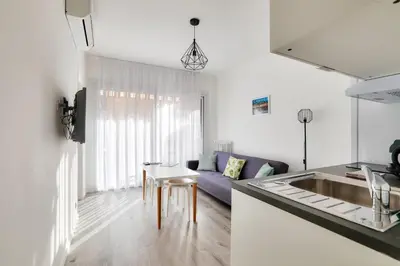 a kitchen and living room with a couch and a table at Le Petit Fleury – Balcony, Calm in Cannes in Cannes