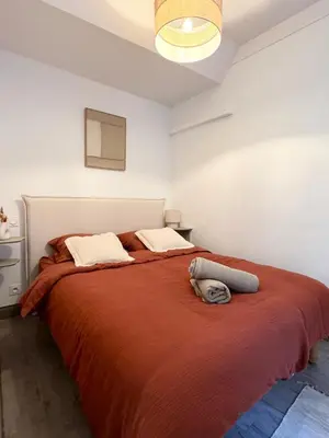 a bedroom with a large bed with a red blanket at La Perle du Suquet, zone piétonne in Cannes