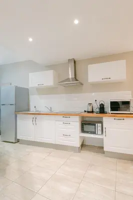 a kitchen with white cabinets and a refrigerator at La Perle du Suquet, zone piétonne in Cannes
