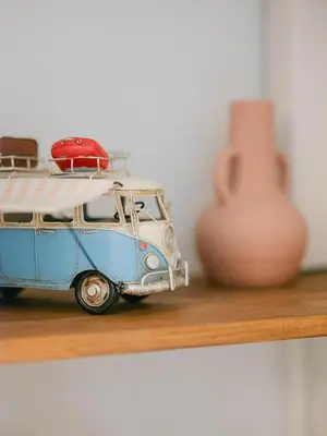 a toy van sitting on a shelf next to a vase at La Perle du Suquet, zone piétonne in Cannes
