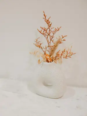a white vase with a plant in it at La Perle du Suquet, zone piétonne in Cannes