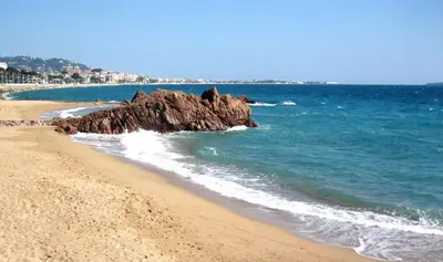 a beach with a rock formation in the water at Cannes, La Palme d'Or in Cannes