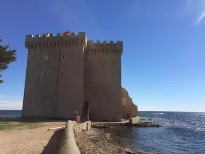 two people standing in front of a castle in the water at Cannes, La Palme d'Or in Cannes