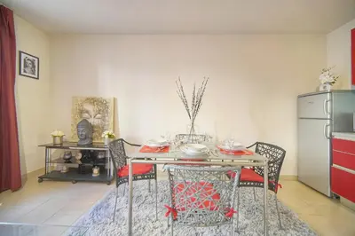 a dining room with a table and a kitchen at Immogroom - T2 - AC - Suquet in Cannes