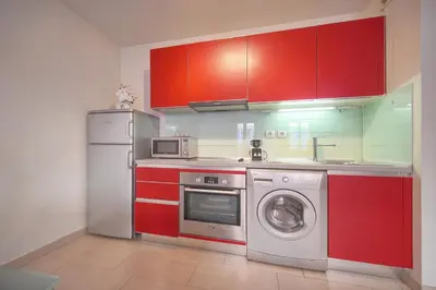 a kitchen with red cabinets and a washing machine at Immogroom - T2 - AC - Suquet in Cannes