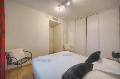 a bedroom with a bed with a black dog on it at Immogroom - T2 - AC - Suquet in Cannes