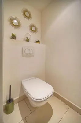 a bathroom with a toilet and two mirrors on the wall at Immogroom - T2 - AC - Suquet in Cannes