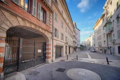 an alley with an archway in a city with buildings at Immogroom - T2 - AC - Suquet in Cannes
