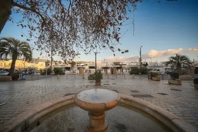 a fountain in the middle of a courtyard with palm trees at Immogroom - T2 - AC - Suquet in Cannes