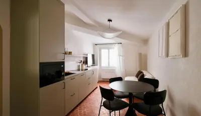 a kitchen with a table and chairs in a room at Exceptional facing Palais Cannes 3 in Cannes