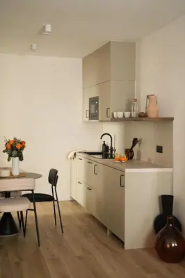 a kitchen with white cabinets and a table and a table and chairs at Exceptional facing Palais Cannes1 in Cannes