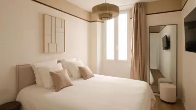 a white bed in a room with a window at Exceptional facing Palais Cannes1 in Cannes
