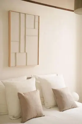 a white bed with white pillows and a picture on the wall at Exceptional facing Palais Cannes1 in Cannes