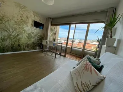 a living room with a bed and a large window at Studio and breakfast in Cannes