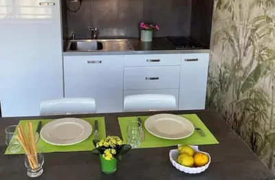 a kitchen with a table with plates and fruit on it at Studio and breakfast in Cannes