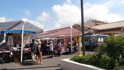 a group of people standing around an outdoor market at Studio and breakfast in Cannes