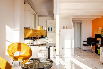 a kitchen with a yellow chair and a white refrigerator at Sunny duplex close to Croisette, free parking in Cannes