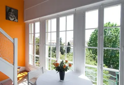 a room with windows and a vase of flowers on a table at Sunny duplex close to Croisette, free parking in Cannes