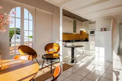 a kitchen with a table and chairs and a refrigerator at Sunny duplex close to Croisette, free parking in Cannes