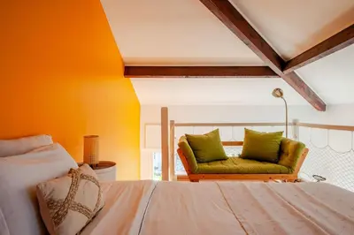 a bedroom with a bed and a couch at Sunny duplex close to Croisette, free parking in Cannes