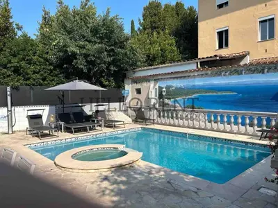 a swimming pool with an umbrella next to a building at Grande Villa Cannes Centre havre de paix in Cannes