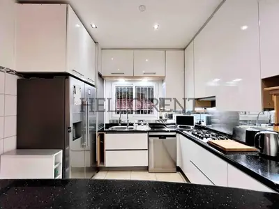 a kitchen with white cabinets and a black counter top at Grande Villa Cannes Centre havre de paix in Cannes